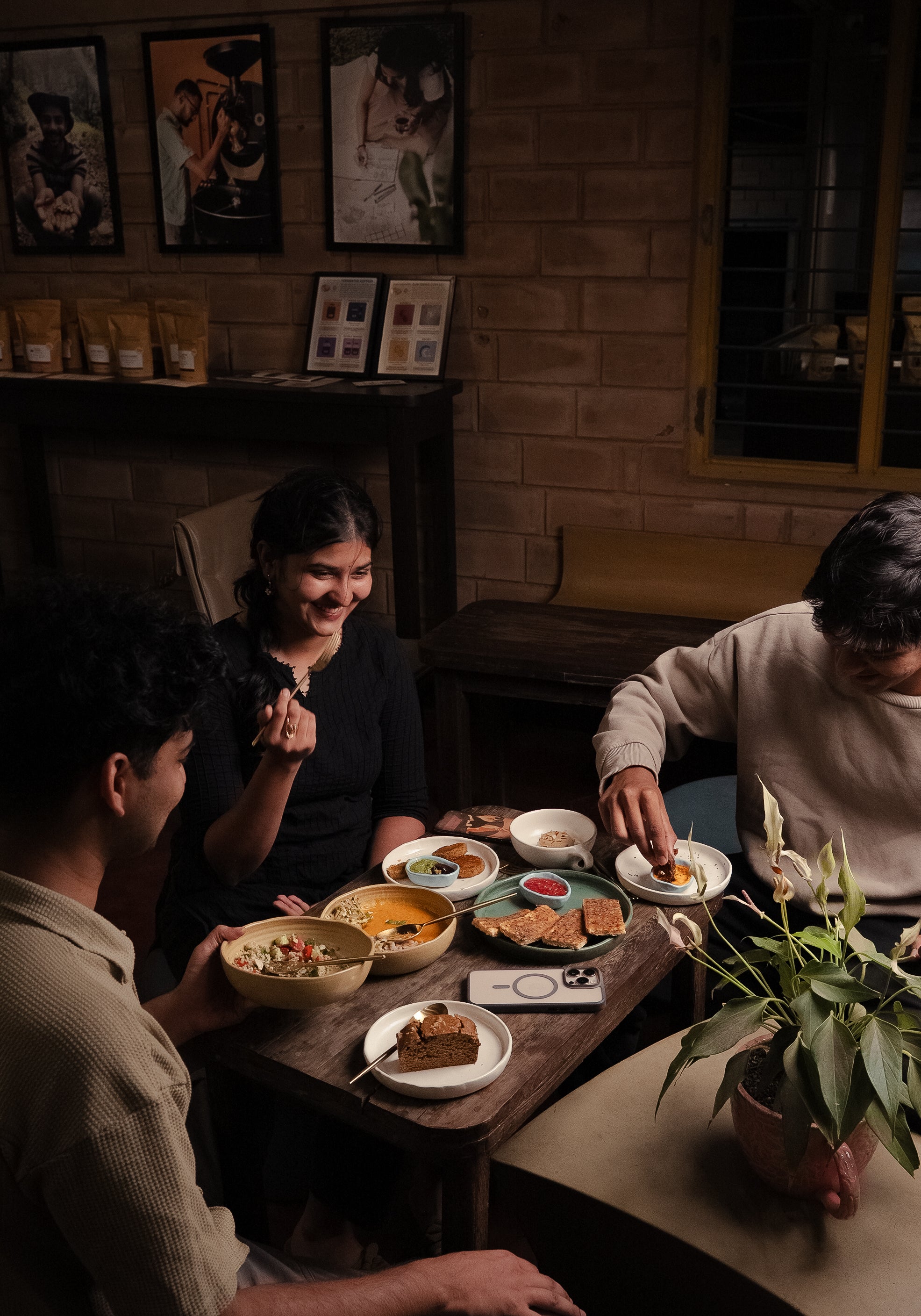 People sitting around a table with food in a cozy indoor setting